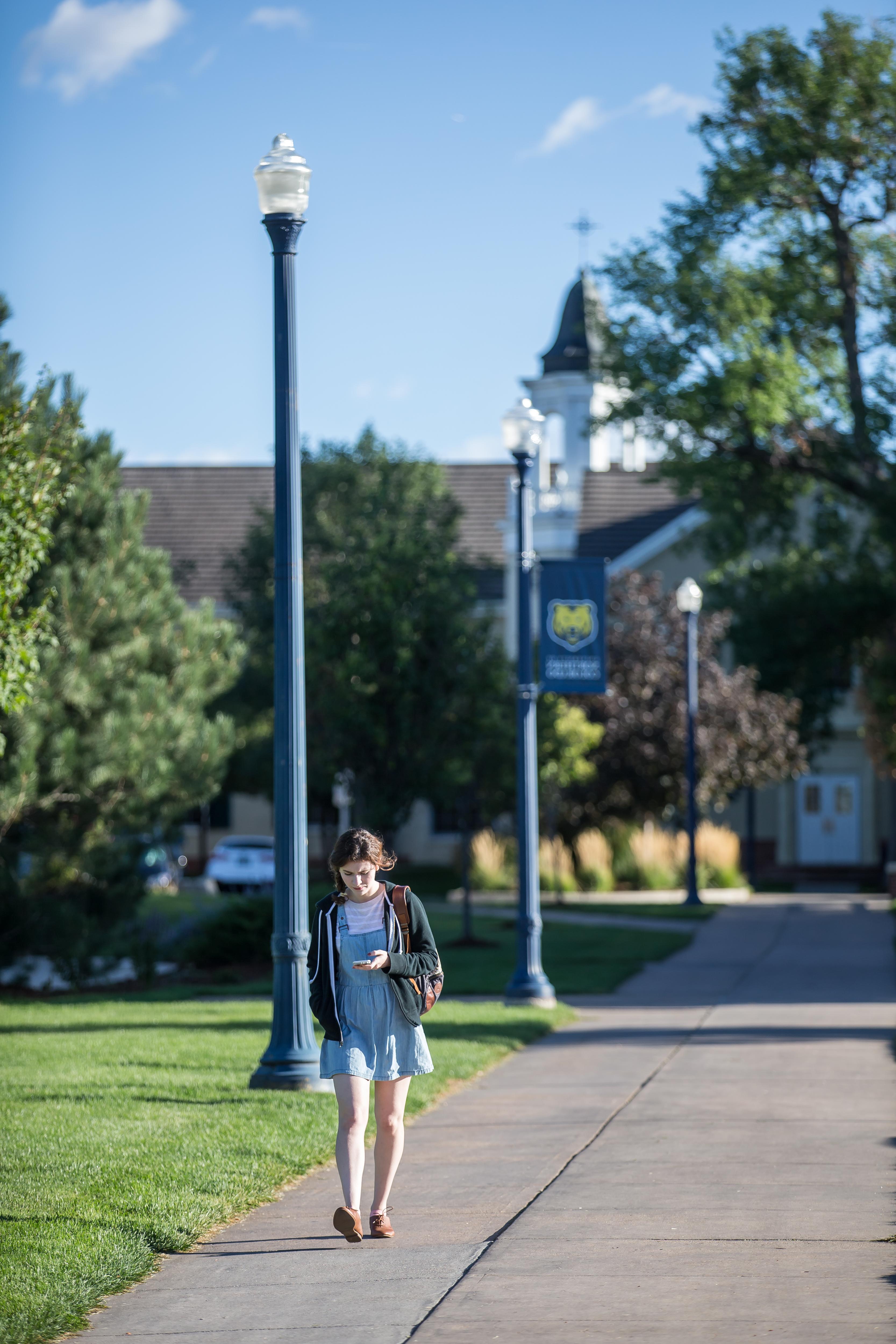 Student walking on UNC campus in the summer.